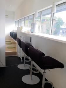 an office with chairs and a counter with windows at Santiago Guesthouse Kyoto in Kyoto