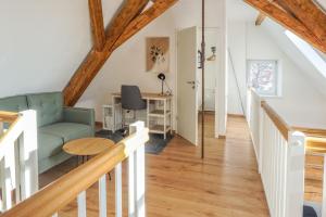 a living room with a green couch and a table at Ferienwohnung "Alpspitze" - Familienfreundliche Maisonette in Mering in Mering