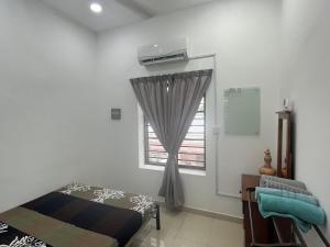 een slaapkamer met een bed en een raam bij KUL Rest House in Labu