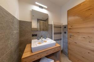 La salle de bains est pourvue d'un lavabo blanc et d'un miroir. dans l'établissement A CASA Granat, à Sölden