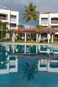 un complejo con una piscina y una palmera en Sultan Palace Beach Retreat Mombasa en Mombasa