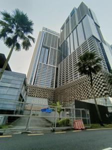 a tall building with two palm trees in front of it at Platinum 2 KLCC NewLuxuryCondo By Langitel with InfinityCityView SwimmingPool in Kuala Lumpur
