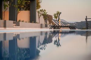 a group of chairs sitting next to a swimming pool at Heaven's Door in Kalámion