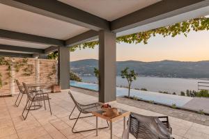a patio with chairs and tables and a view of the water at Heaven's Door in Samos