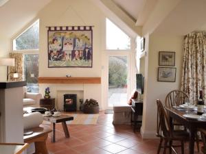 uma sala de estar com uma mesa e uma lareira em Tucking Cottage em Treffgarne