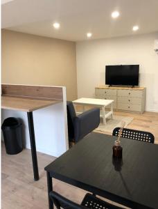 a living room with a table and a tv at Immeuble rénové au centre d'Auch. in Auch