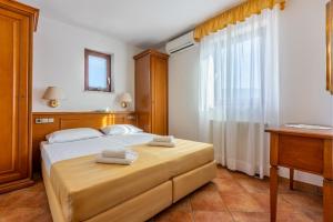 a bedroom with a bed with towels on it at Guest House Agava in Crikvenica