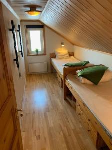 Cette petite chambre comprend 2 lits et une fenêtre. dans l'établissement Cabin in Bruksvallarna, à Bruksvallarna