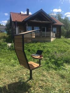 un banc avec un ordinateur portable devant une maison dans l'établissement Cabin in Bruksvallarna, à Bruksvallarna