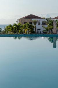 a view of a swimming pool with a house and the ocean at Sultan Palace Beach Retreat Mombasa in Mombasa