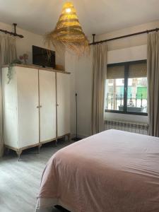 a bedroom with a bed and a chandelier at Aura Rural, Montes de Toledo in San Pablo de los Montes