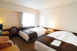 Postel nebo postele na pokoji v ubytování Niigata Toei Hotel