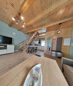 een grote woonkamer met een houten plafond en een trap bij Leśna Ostoja in Lubawka
