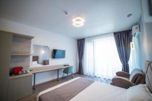 Cette chambre comprend un lit et un bureau. dans l'établissement Hotel Ana Eforie, à Eforie Nord