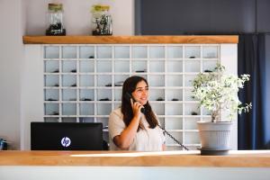 una mujer hablando por un celular en una oficina en Brione Green Resort, en Riva del Garda