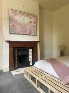 1 dormitorio con 1 cama y chimenea en Waterloo Cottage en Hobart