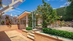 a house with a garden with trees and a fence at Waterloo Cottage in Hobart