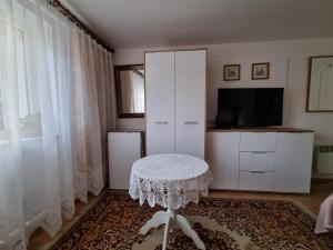 sala de estar con mesa y TV en Wojciechówka, en Ustka