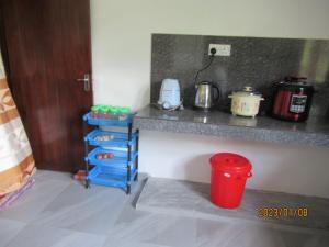 uma cozinha com um balcão e uma lata de lixo vermelha em pumindu homestay em Matara