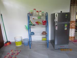 uma cozinha com uma prateleira azul ao lado de um frigorífico em pumindu homestay em Matara