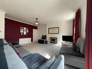 a living room with a couch and a television at Large 4 double bedroomed townhouse in central Holmfirth in Holmfirth