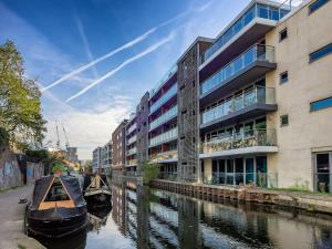 two boats parked in a canal in front of a building at Luxury 3-Bedroom Townhouse in Hackney in London