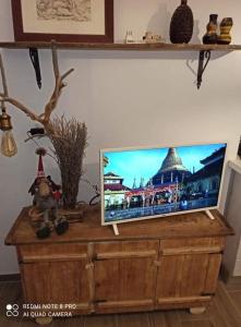 fuga sui sibillini في Gualdo di Macerata: يوجد تلفزيون بشاشة مسطحة فوق خزانة خشبية