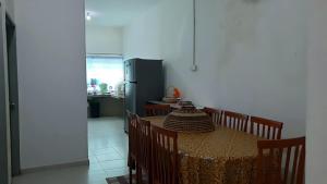 a kitchen with a table with chairs and a refrigerator at Homestay Ahmad Kuala Kangsar in Kuala Kangsar