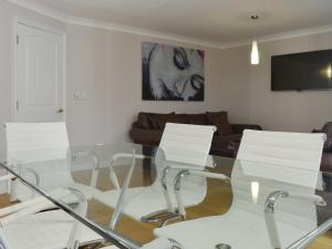 sala de estar con mesa de cristal y sillas blancas en Hollies Cottage 14 -ukc4537, en Martock