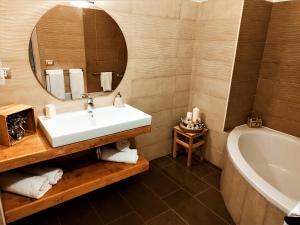 een badkamer met een wastafel, een bad en een spiegel bij Hotel Altopiano Delle Rocche in Rocca di Mezzo +33 foto's