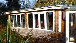 an extension to a house with sliding glass doors at La maison des musiciens in Digosville