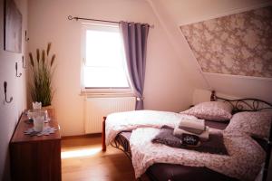 a small bedroom with a bed and a window at FeWo Düver in Loxstedt