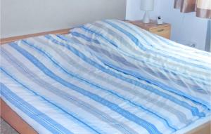 a blue and white striped comforter on a bed at 1 Bedroom Awesome Home In Prmzurlay in Prümzurlay