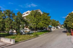 an empty street in a residential neighborhood with trees at Guest House Agava in Crikvenica