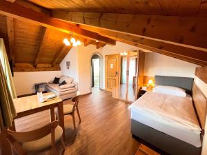 a bedroom with a bed and a desk in a room at Hotel Garni Brunnthaler in Garmisch-Partenkirchen