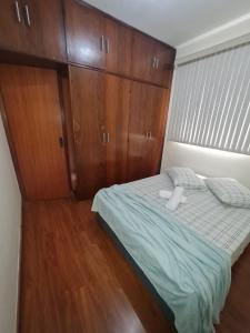 ein Schlafzimmer mit einem Bett mit einer Holzwand in der Unterkunft apartamento completo in Contagem