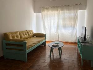 ein Wohnzimmer mit einem Sofa und einem Tisch in der Unterkunft AQUA in Puerto Madryn