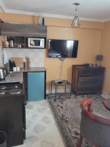a kitchen with a stove and a tv on the wall at Sparkle Residency in Nairobi