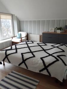 a bedroom with a black and white bed and a chair at Homestay Khomenko in Perechin