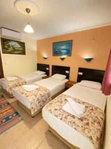 a hotel room with three beds in a room at Sevin Hotel Pension in Bodrum City