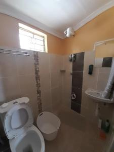 a bathroom with a toilet and a shower and a sink at Sparkle Residency in Nairobi