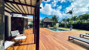 格兰贝伊Villa de luxe, près de la mer et des commerces的房子上的木甲板，配有桌子和长凳