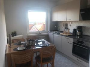 a kitchen with a table and chairs and a window at Ferienwohnung Waschbärglück in Hahnenklee-Bockswiese
