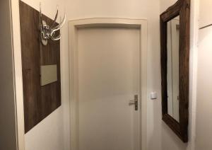a white door in a room with a mirror at Ferienwohnung Waschbärglück in Hahnenklee-Bockswiese
