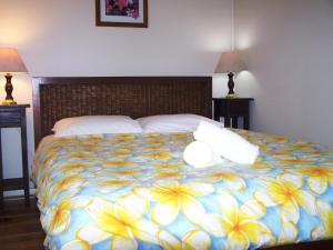 a bedroom with a large bed with a blue and yellow blanket at Pebble Shack in Coles Bay