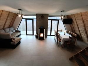 un soggiorno con tavolo e camino di Dream Cottage a Paltin