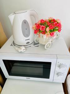 a white microwave with flowers on top of it at Pensiune Roua 2 in Arad