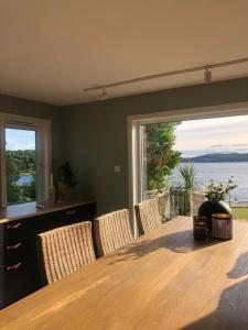 a dining room with a table and chairs and a large window at Strandhytte in Kristiansand