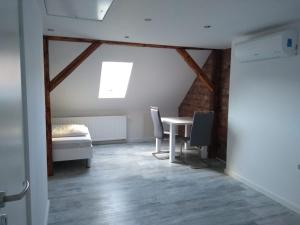 ヒルデスハイムにあるApartment Hildesheimのテーブルとベッド、窓が備わる客室です。