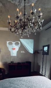 una lámpara de araña con una foto de una mujer con gafas en la pared en Belle Époque, en Solingen